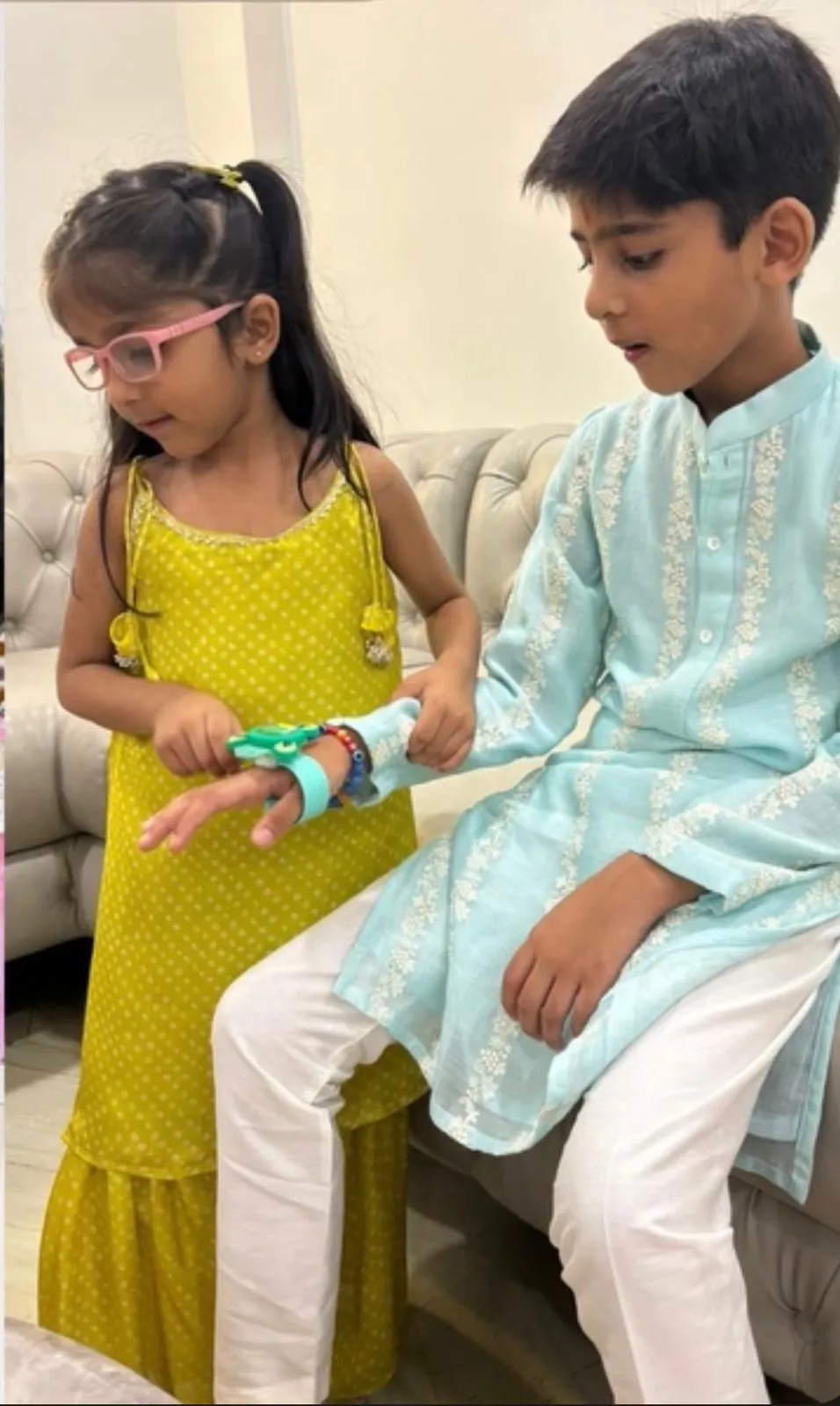 Girl in a lime green dress and boy in a pale blue kurta